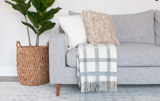 como arrumar manta solta no sofá cinza