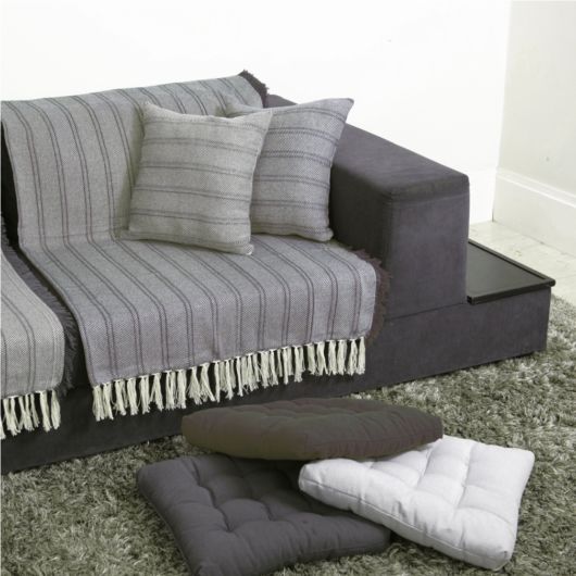 como arrumar manta solta no sofá cinza